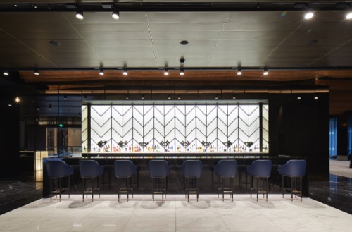 A bar with blue bar stools lined up