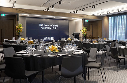 Large event room set up with circular tables at The Business and Events Centre