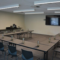 U-shape desks and seating set up within the multi-purpose meeting room at Collins Square