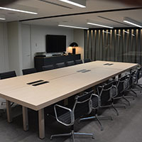 One large desk set up for a meeting within the multi-purpose meeting room at Collins Square