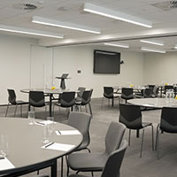 Multiple circular tables set up within the multi-purpose meeting room at Collins Square