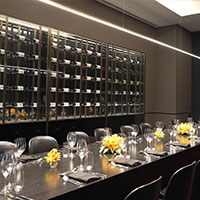 View of the wine racks and dining table within the wine room at Collins Square